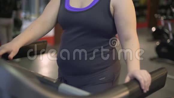 妇女在健身房与肥胖作斗争在跑步机上锻炼锻炼身体以促进健康视频的预览图