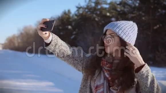 年轻漂亮的女人在阳光明媚的冬日为相机摆姿势视频的预览图