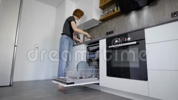 幸福的年轻女性在家中用洗碗机摆放盘子视频的预览图