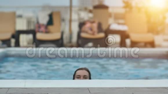游泳后的女孩在游泳池里摆姿势视频的预览图