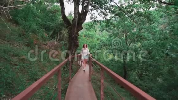 迷人的苗条的活泼的女士金发碧眼沿着铁桥漫步到佐治亚州的奥卡兹峡谷视频的预览图