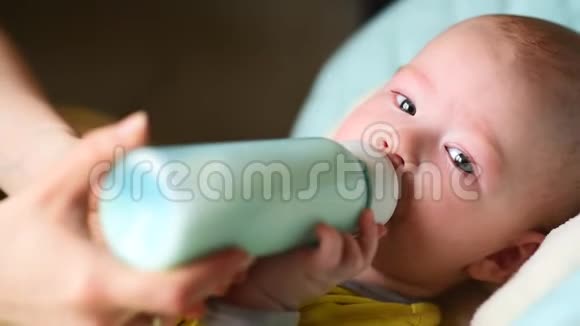 妈妈从瓶子里喂婴儿牛奶视频的预览图
