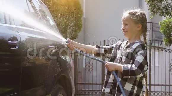 女孩用软管冲洗汽车的水视频的预览图