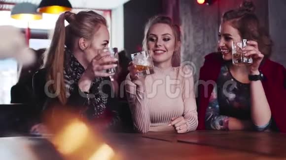 近距离观看三个女孩朋友在俱乐部聊天笑欢呼和喝酒鸡尾酒有机会视频的预览图