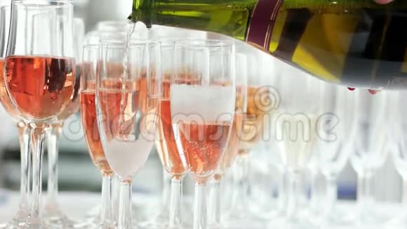 一杯又一杯的香槟杯起泡玫瑰饮料女人拿着瓶子倒酒视频的预览图