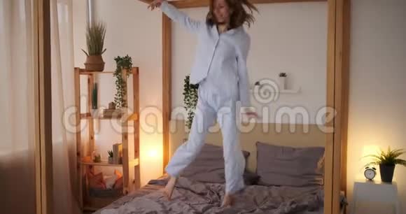 欣喜若狂的女人在床上跳舞视频的预览图