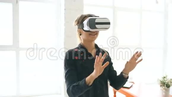 一位戴着VR耳机的女士抬起头试图在室内触摸虚拟现实中的物体视频的预览图