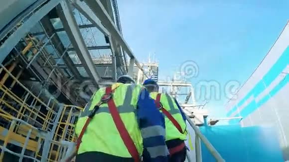 工程师和工人爬上一家大型炼油厂的塔视频的预览图
