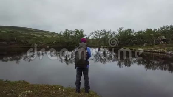 一个徒步旅行者正在看一个小池塘视频的预览图