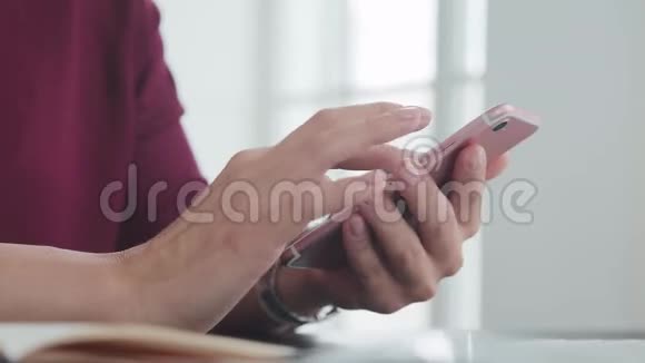 女性手拿着手表和整洁的指甲握着智能手机视频的预览图