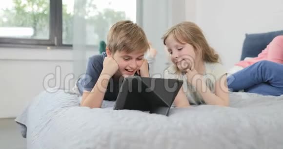 子床上使用平板电脑让父母躺在幸福的笑脸家庭中一起在早晨视频的预览图