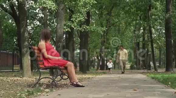 小男孩跑向坐在公园长凳上的妈妈视频的预览图