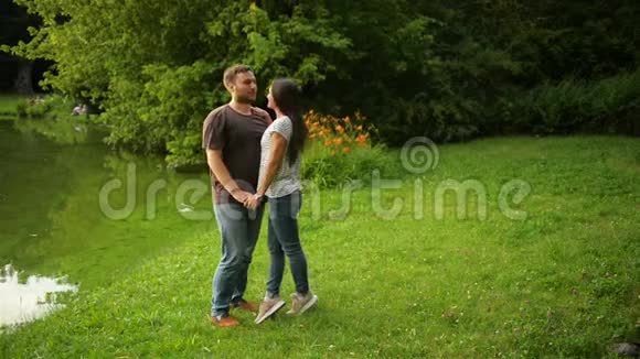这对可爱的夫妇在城市公园接吻的户外肖像女人和男人在外面相爱视频的预览图