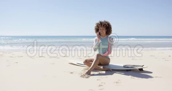 在海滩上打电话的女人视频的预览图