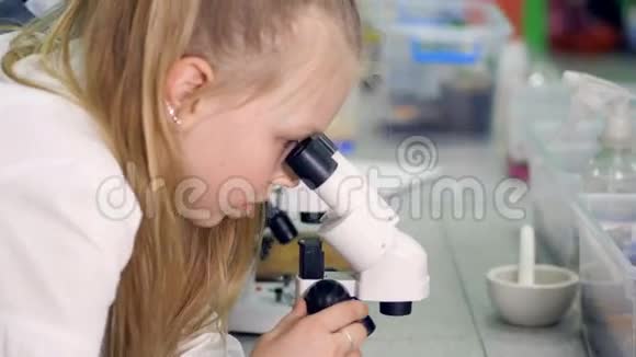 女孩在显微镜下看样品的特写4K视频的预览图