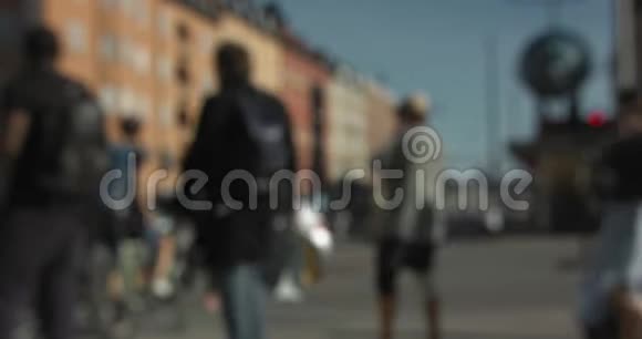 模糊的汽车和人们在斯德哥尔摩市中心的一个十字路口步行和骑自行车视频的预览图