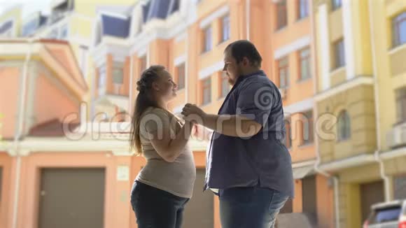 在城市约会时牵手相爱的幸福的胖夫妻温柔的关系视频的预览图