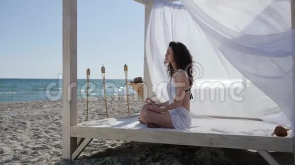 女人在河堤上做瑜伽深呼吸女孩到海边女人在海滩上冥想视频的预览图