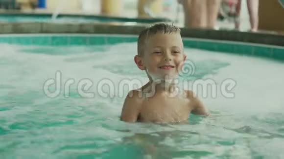 小男孩在游泳池里玩视频的预览图