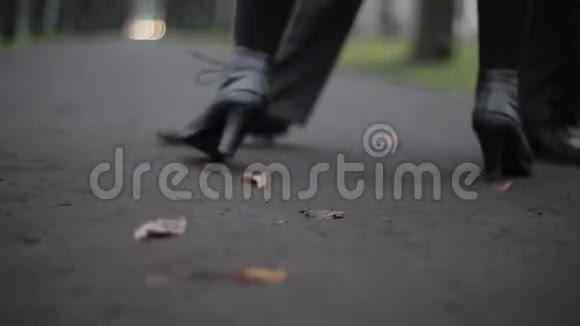 男人女人穿着黑色皮鞋在树叶覆盖的地上跳舞视频的预览图