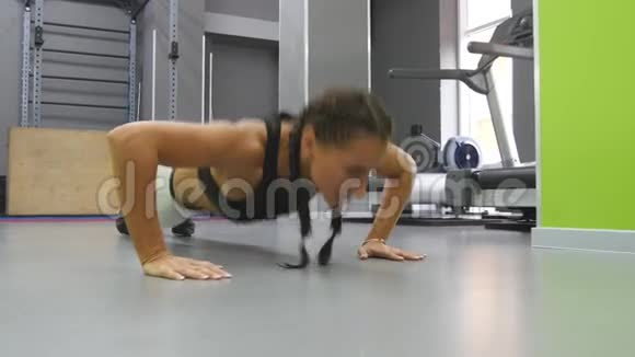 适合肌肉发达的女人在健身房做俯卧撑在希思俱乐部训练年轻的运动女孩女运动员视频的预览图