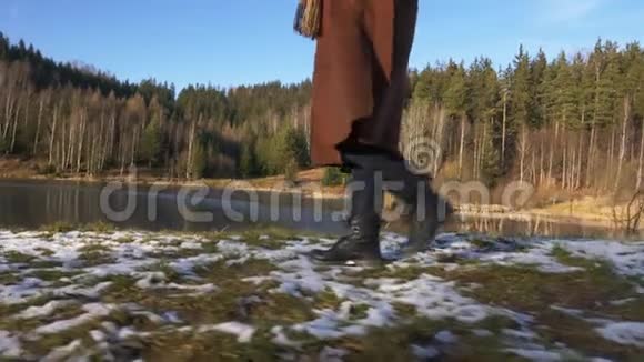 穿靴子的女人在雪地里散步视频的预览图
