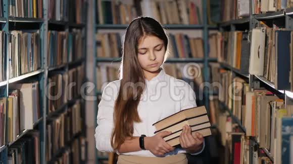图书馆里有书的女孩的肖像视频的预览图