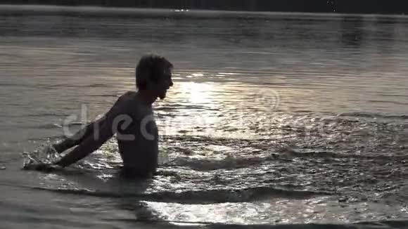 欢乐的人在夕阳西下在湖中扬起溪水视频的预览图