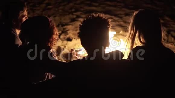 从不同的人群中可以看到深夜坐在炉火旁互相拥抱的画面快乐视频的预览图