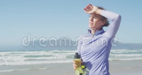 疲惫的运动女子在海滩上视频的预览图