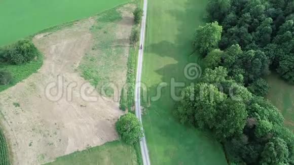 从空中俯瞰阿米什马和马车行驶在乡间土路上视频的预览图