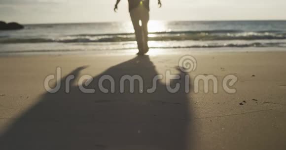 海滩上一位老人的后景视频的预览图