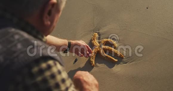海滩上一位老人的后景视频的预览图
