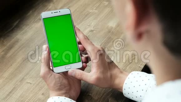 男士使用带有绿色屏幕显示的手机视频的预览图