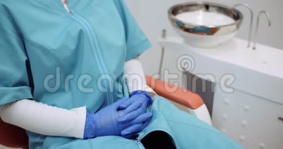 疲惫的牙医坐在牙医椅上视频的预览图
