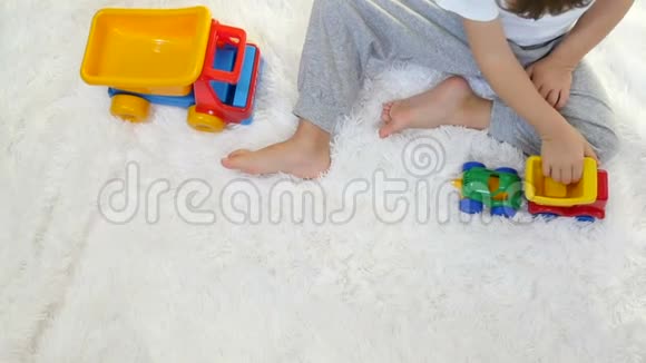 一个小孩在白色背景下缓慢地玩玩具卡车视频的预览图