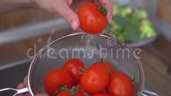 女人手在厨房里洗成熟的西红柿视频的预览图