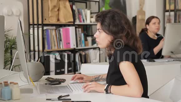 两名妇女在室内电脑旁办公视频的预览图