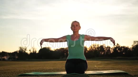 健身妇女在日落时锻炼瑜伽姿势视频的预览图