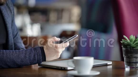 关闭男性手拿着智能手机和打字信息年轻商人拿着笔记本电脑和视频的预览图
