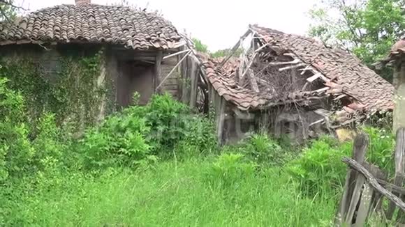 旧的和倒塌的站在废弃的房子旁边视频的预览图