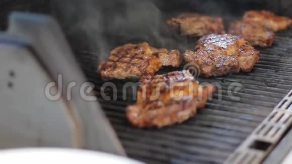 肉牛排是在煤气烤架上煮熟的露天美味的肉菜烟来自食物厨师把牛肉翻过来视频的预览图