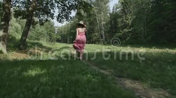 戴帽子的年轻女子沿着小径奔跑的后景慢动作视频的预览图