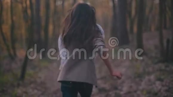 年轻的小女孩有长长的黑发和时尚的外观害怕的小女孩在森林里奔跑她环顾四周视频的预览图