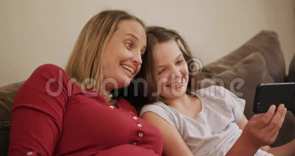 妈妈和女儿在沙发上打电话视频的预览图