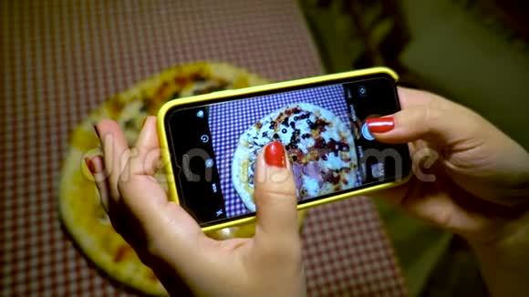 人和食物的概念餐馆里的年轻女子用手机相机拍食物视频的预览图