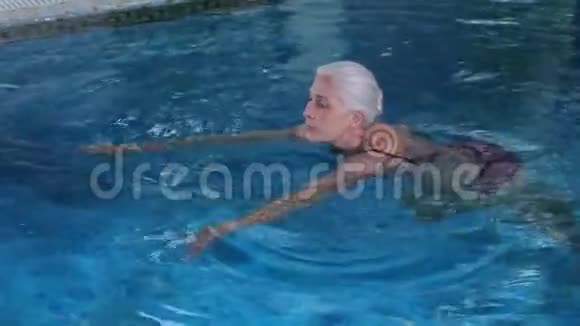 快乐的老年妇女在温泉酒店游泳池游泳视频的预览图