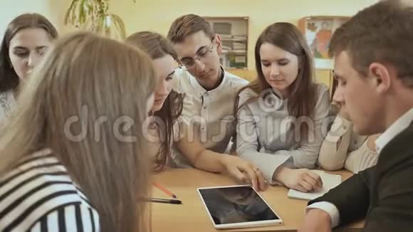 同学们围坐在课桌旁用平板讨论学校的任务俄罗斯学校视频的预览图