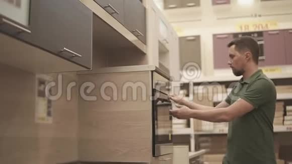 买方正在家具店检查厨房的烤箱视频的预览图