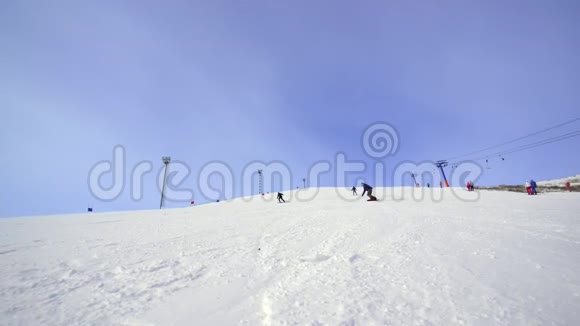 滑雪者在晴朗的天气下在雪坡上滑雪视频的预览图